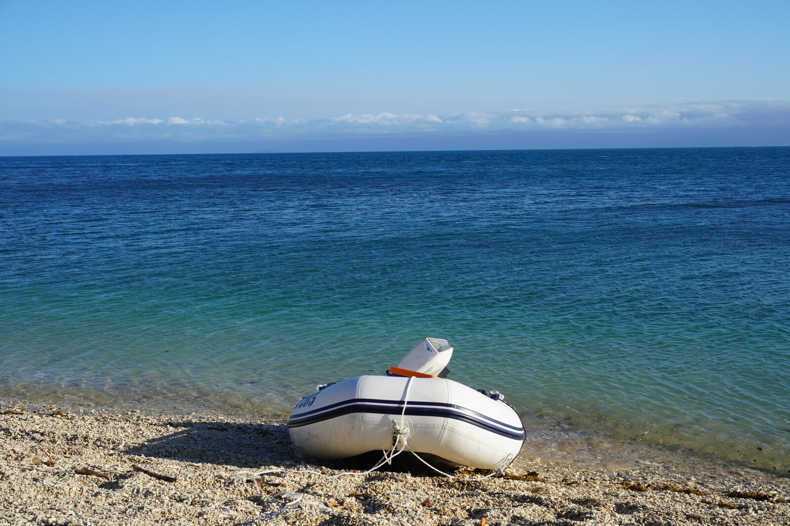 Destiny Blue's tender pulled up on a quiet coral beach off Port Douglas, with the reef waters stretching to the horizon